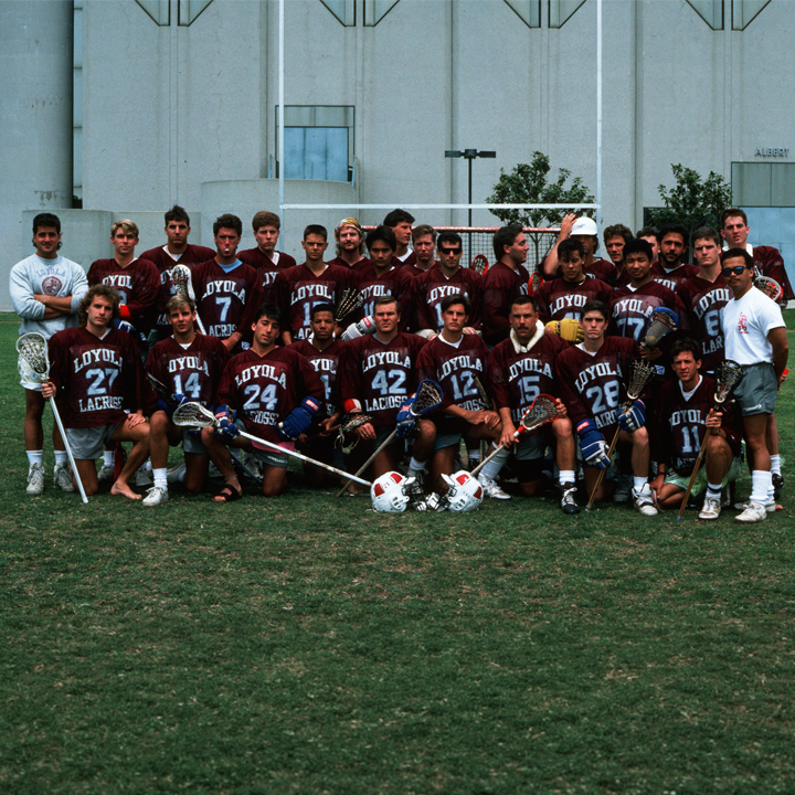 The 1989 LMU men's lacrosse team poses for a team photo with Gersten Pavilion in the background